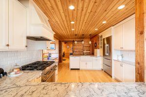 kitchen remodel with wood floors, walls, and ceilings and marble countertops